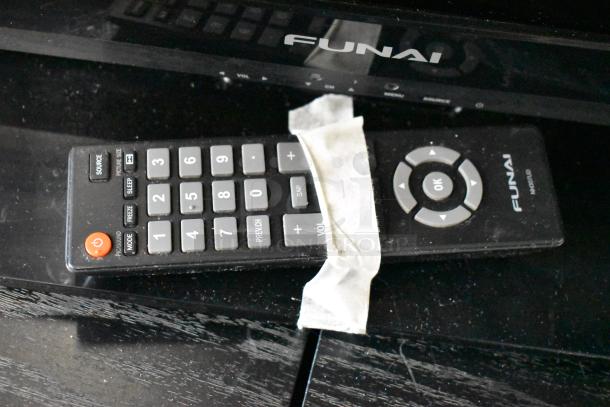 Funai TV remote control with numeric keypad and directional pad, slightly worn condition, masking tape on front.