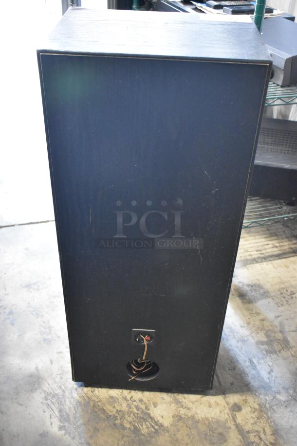 Black wooden speaker cabinet with visible rear wiring and connectors; shows light wear, suitable for audio equipment use.