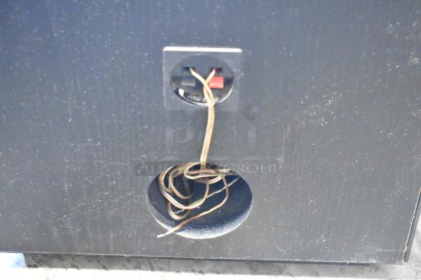 Black wood speaker with visible wiring and input port. Condition shows wear; suitable for audio enthusiasts or collectors.