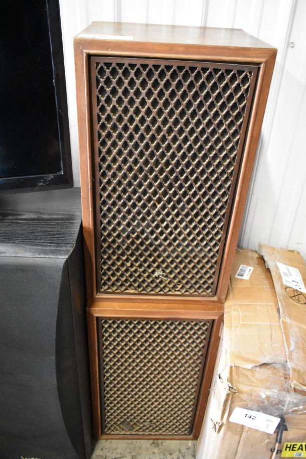 Vintage wood-cased speakers with lattice grills, in good condition, minor wear. Unmarked, stackable design.