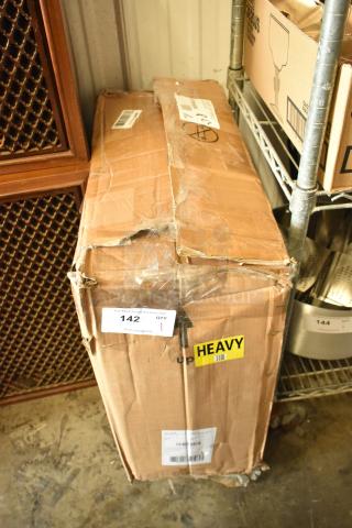 Damaged cardboard box on shelf with "HEAVY" label and auction lot number 142. Box shows significant wear.