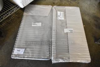 Two Delfield OEM stainless steel wire shelves, new, labeled as part 3077989, in original packaging, Qty 1, lot 143.