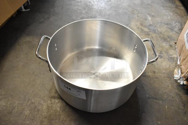 Large stainless steel stockpot with dual handles, showing some signs of use. Auction label reads "144 QTY 1".