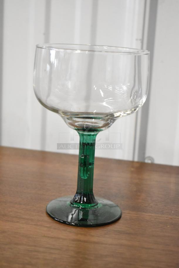 Clear glass goblet with green stem, excellent condition, no visible markings, suitable for display or use, elegant design.