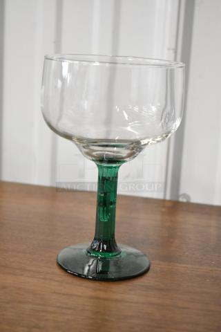 Clear glass goblet with green stem, excellent condition, no visible markings, suitable for display or use, elegant design.