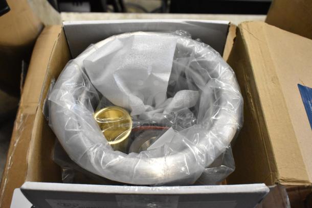 New stainless steel sink, packaged in a cardboard box with protective wrapping, brass fittings visible.