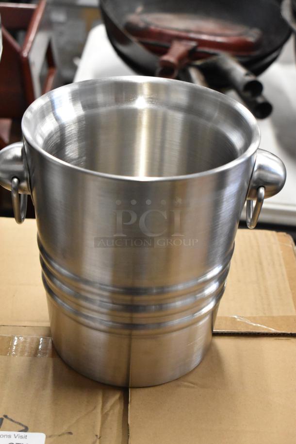 Stainless steel bucket with dual handles, ribbed design, in excellent condition, suitable for multipurpose use.