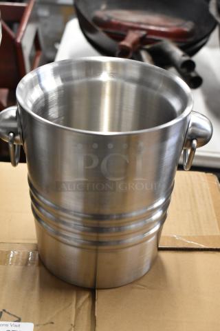 Stainless steel bucket with dual handles, ribbed design, in excellent condition, suitable for multipurpose use.