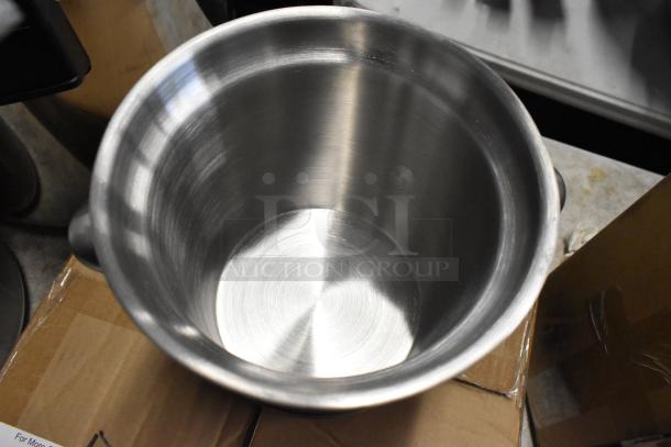 Stainless steel mixing bowl, used condition, brushed finish, circular design, no visible dents or scratches, placed on cardboard.