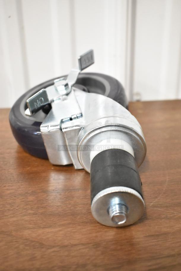 Heavy-duty caster wheel with metal swivel bracket, rubber tire, and brake lever marked "ON." Appears in excellent condition.