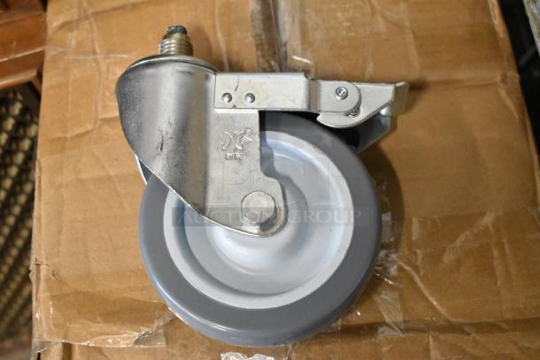 Swivel caster wheel with brake, gray rubber, metal mounting plate. Markings indicate capacity and manufacturer. Good condition.