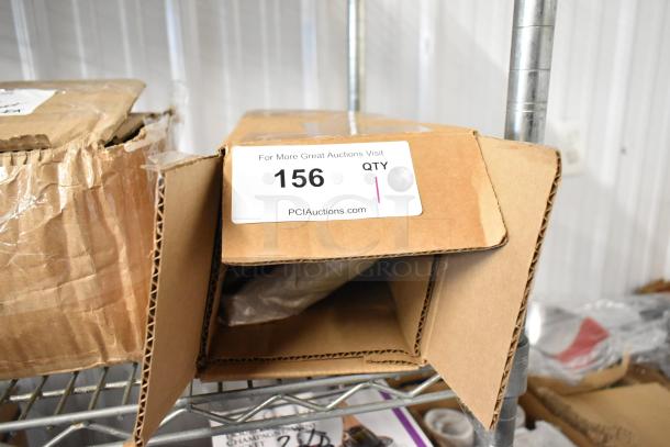 Open cardboard box on metal shelf, labeled "156 QTY" from PCIAuctions.com, showing potential auction item inside.