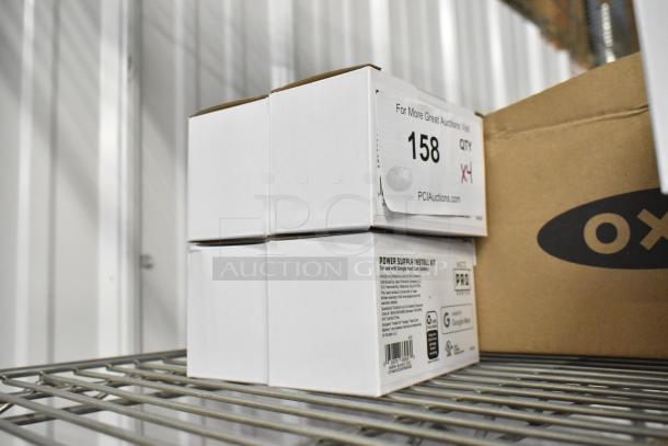 Four white boxes marked "Power Supply Install Kit" for Google Nest on a metal shelf, auction tag number 158, quantity 4.