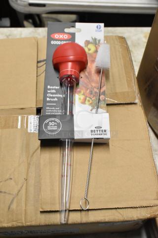 Oxo Good Grips baster with cleaning brush, new in packaging. Features 50% recycled content, includes measurement markings.