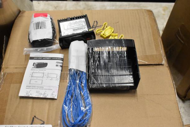 Electronics kit with wiring, labeled controller, manual, and mounting accessories on a cardboard box.