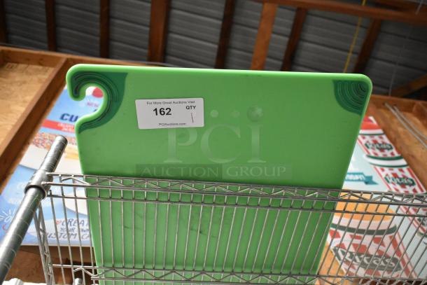 Green commercial cutting board with U-groove design, auction tag reading "162 QTY 1," mounted on metal rack.