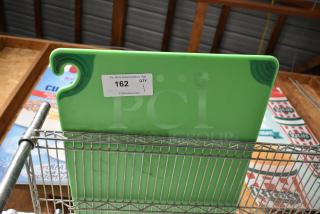 Green commercial cutting board with U-groove design, auction tag reading "162 QTY 1," mounted on metal rack.