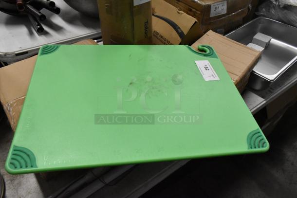 Green cutting board with corner grips and measurement markings on the edge. Used condition with visible wear marks. Auction tag "162".