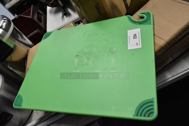 Green plastic cutting board with corner grips and visible wear. Label marked "162 QTY 1." Suitable for kitchen use.