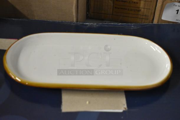 Oval ceramic platter with a mustard yellow rim, in good condition. Subtle speckled pattern. No visible markings.