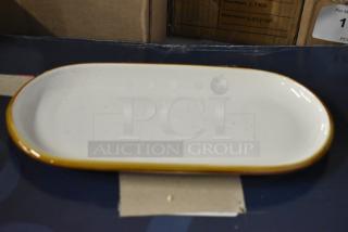 Oval ceramic platter with a mustard yellow rim, in good condition. Subtle speckled pattern. No visible markings.