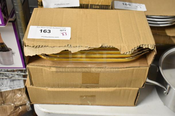Box of nested yellow trays, partially opened. Auction label reads "163 QTY 13," from PCI Auctions. Appears in good condition.
