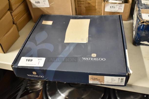 Waterloo deck-mount 4" center faucet in original blue box, label indicates model and features. Box shows minor wear.