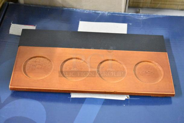 Wooden coin holder with four circular indents on a rectangular base. Good condition, no visible markings or labels.