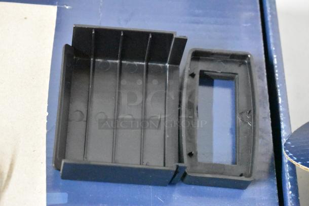 Black plastic rectangular holder with open slots; used for organization or storage. Appears slightly used with minor scuffs.