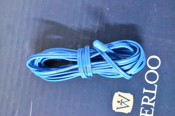 Coiled blue extension cord on surface with "Waterloo" label; appears in good condition, suitable for various uses.