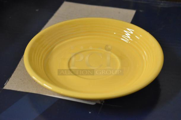 Yellow ceramic plate with concentric rings, glossy finish, in good condition. Diameter approximately 10 inches.
