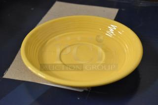 Yellow ceramic plate with concentric rings, glossy finish, in good condition. Diameter approximately 10 inches.