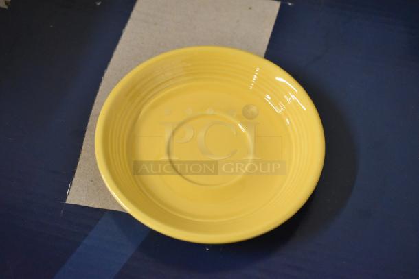 Yellow ceramic saucer with concentric circle design, glossy finish, and in excellent condition. No visible markings or labels.