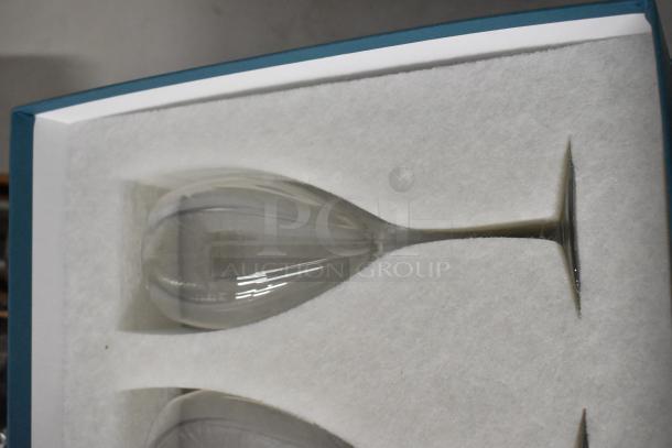 Boxed set of crystal wine glasses, new condition, in protective packaging, highlighting elegant, slender design and clarity.