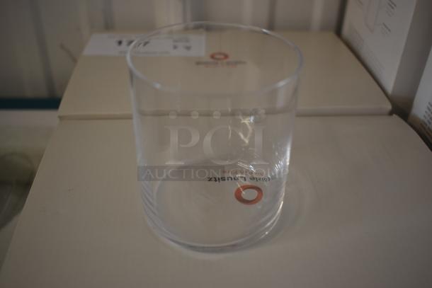 Clear glass tumbler with "Fragile Gauslitz" marking, in new condition, placed on a box.
