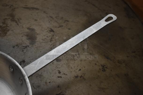 Metal frying pan with long, riveted handle, in used condition with visible wear. Ideal for rustic or heavy-duty cooking.