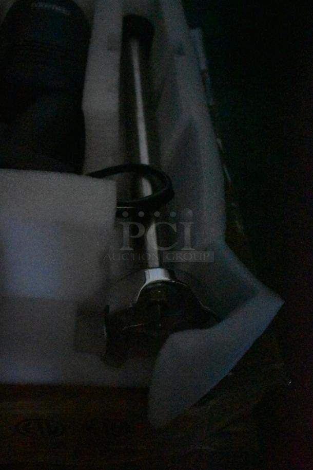 Electric hand blender with stainless steel shaft in original packaging. Appears unused, foam padding intact.