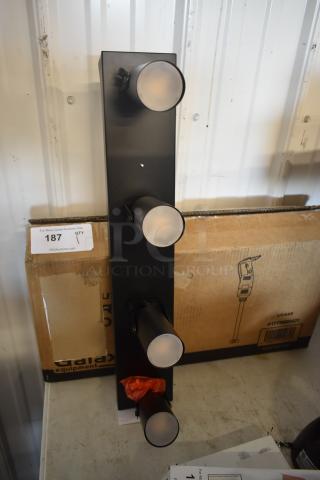 Black four-light wall fixture with frosted glass covers, in new condition. Includes an auction tag numbered 187.