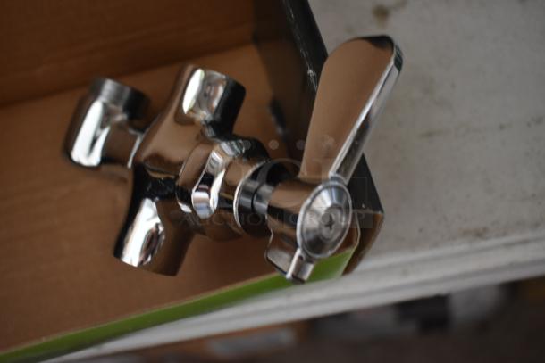 Chrome-finished faucet handle in new condition, showing a sleek design with an integrated screw on the handle base, packaged in a box.