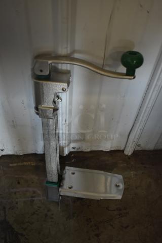 Manual truck landing gear with a green handle, steel construction, moderate wear, mounted on a metal base.
