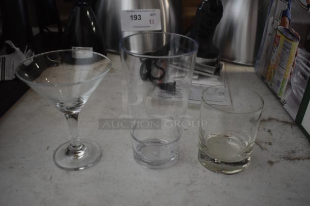 Set of three drinking glasses: martini glass, tall tumbler, and whiskey glass, in good condition on a countertop.