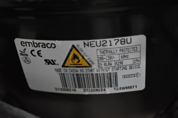 Embraco NEU2178U compressor label showing CE, RoHS marks, thermally protected, 208-230V, R290, risk of fire warning.