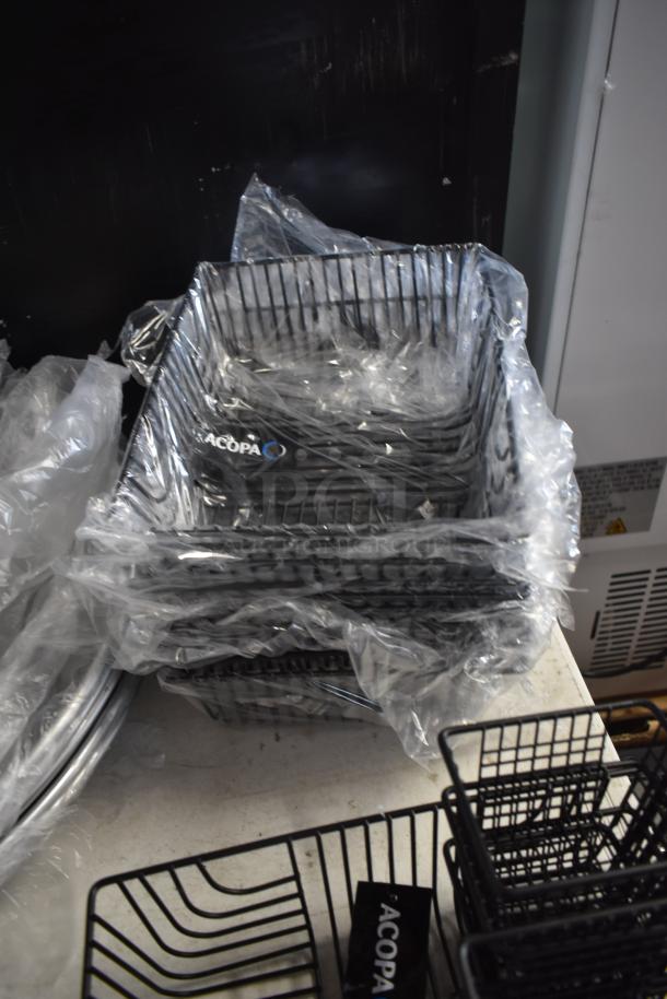 Stack of Acopa black wire baskets, new in plastic wrap, ideal for storage or display, visible brand label indicating quality.