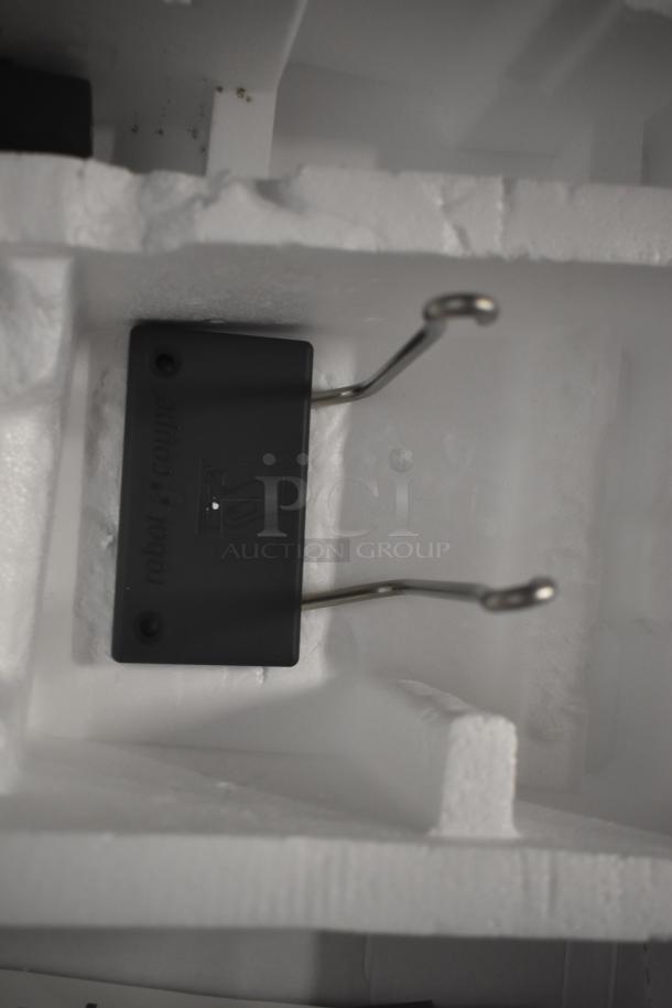 Robot Coupe metal hook attachment in foam packaging. Black label with "robot coupe." Pristine condition.