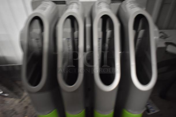 Four grey and green hand sanitizer dispensers, standing side by side. Slightly blurred image, no distinct markings visible.