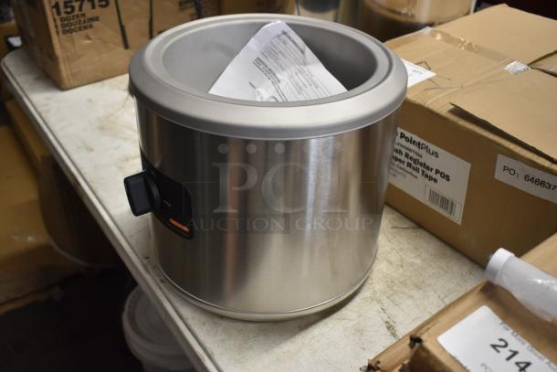 Stainless steel ice cream maker with control dial, includes instructions inside, in excellent condition, on table.