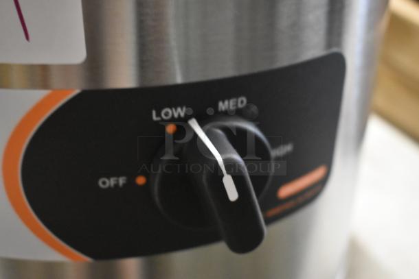 Stainless steel appliance knob showing Low and Med settings, black dial with white indicator strip.