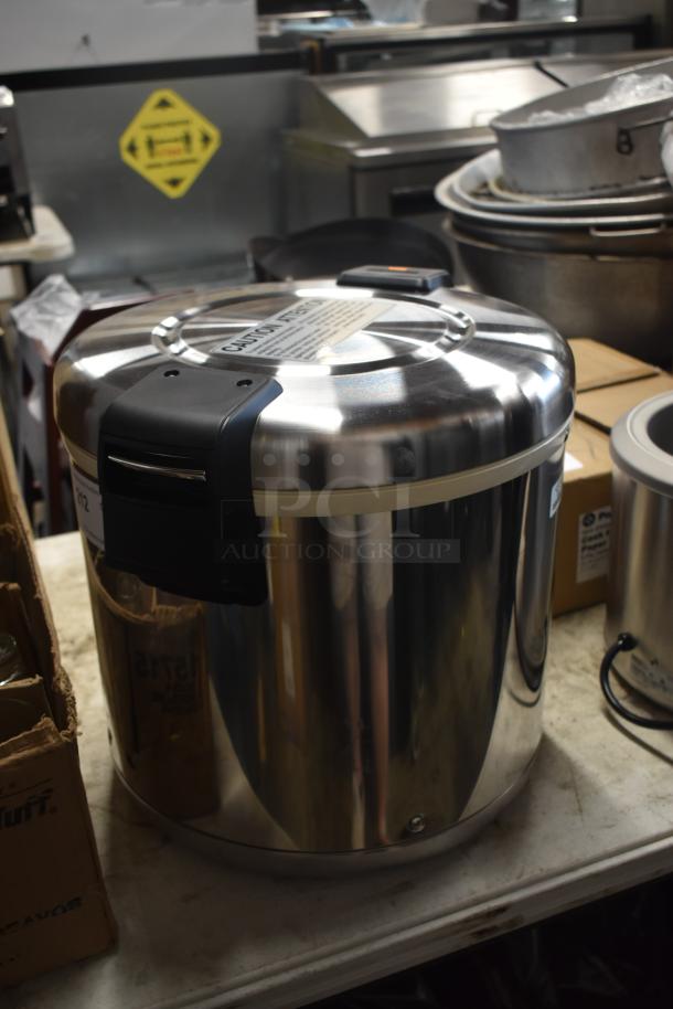 Stainless steel commercial rice warmer, excellent condition, features safety lid latch, caution label on top.