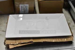 White rectangular ceramic serving platter, glossy finish, new condition. Placed on cardboard packaging.