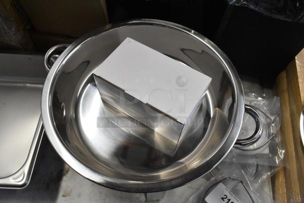 Large stainless steel bowl with double handles, pristine condition, featuring a white cardboard box inside.